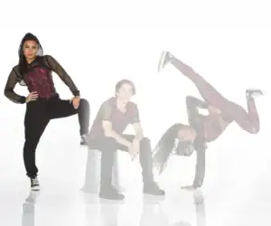 Three dancers pose in coordinated red and black outfits.