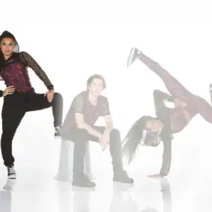 Three dancers pose in coordinated red and black outfits.
