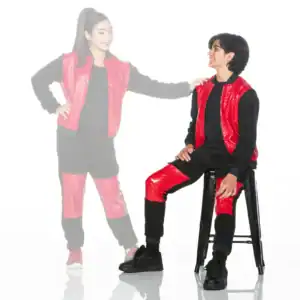 Two models wearing red and black outfits, one seated.