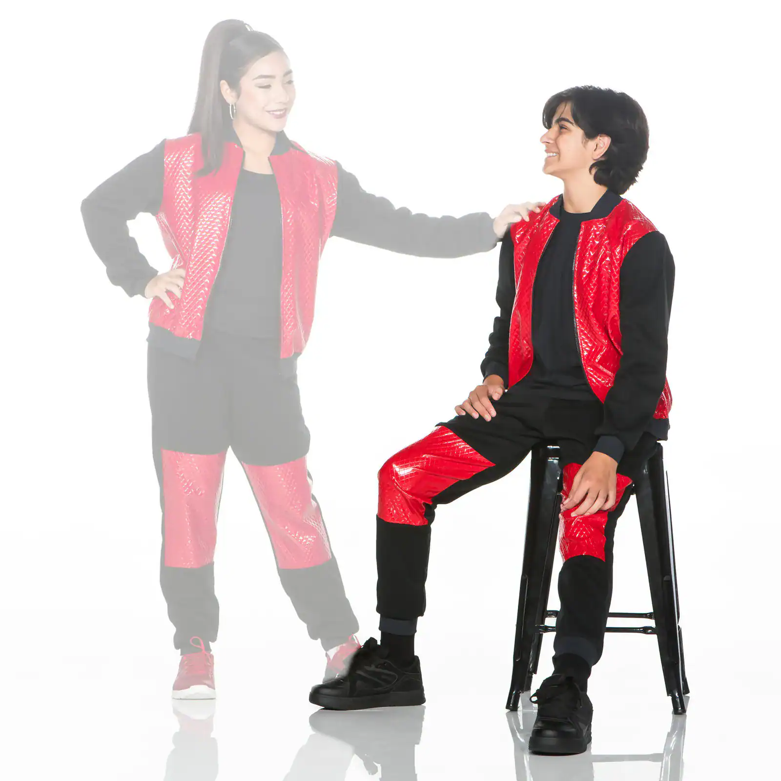 Two models wearing red and black outfits, one seated.