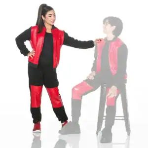 Woman wearing red and black outfit beside faded seated man