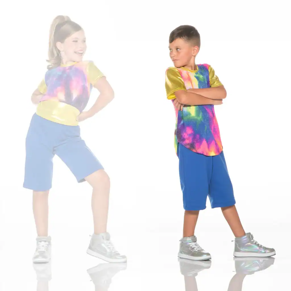 Two children wearing colorful galaxy-print shirts and blue shorts