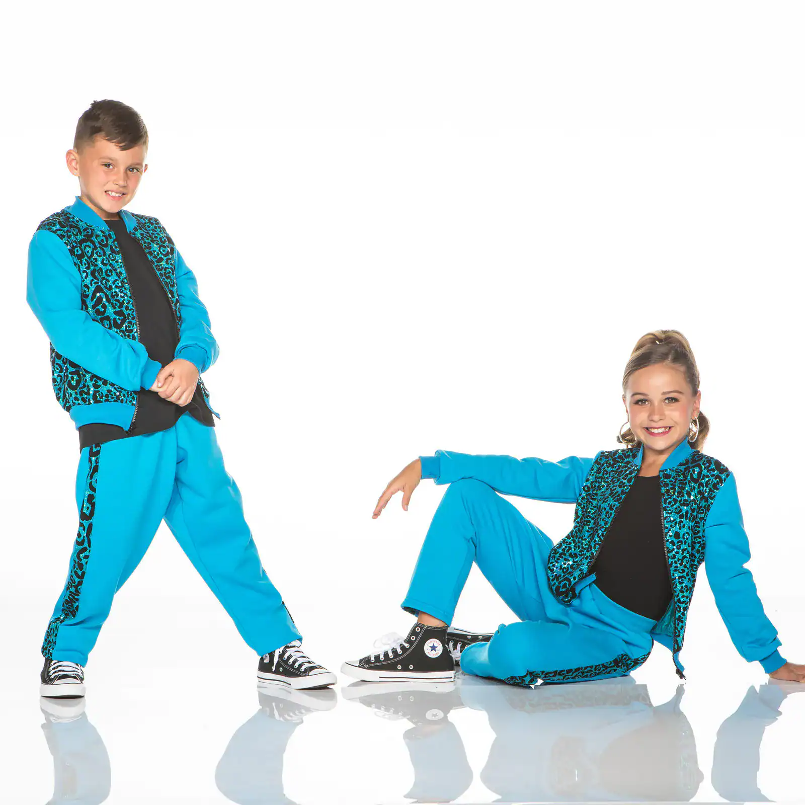Two children in matching turquoise leopard-print dance outfits