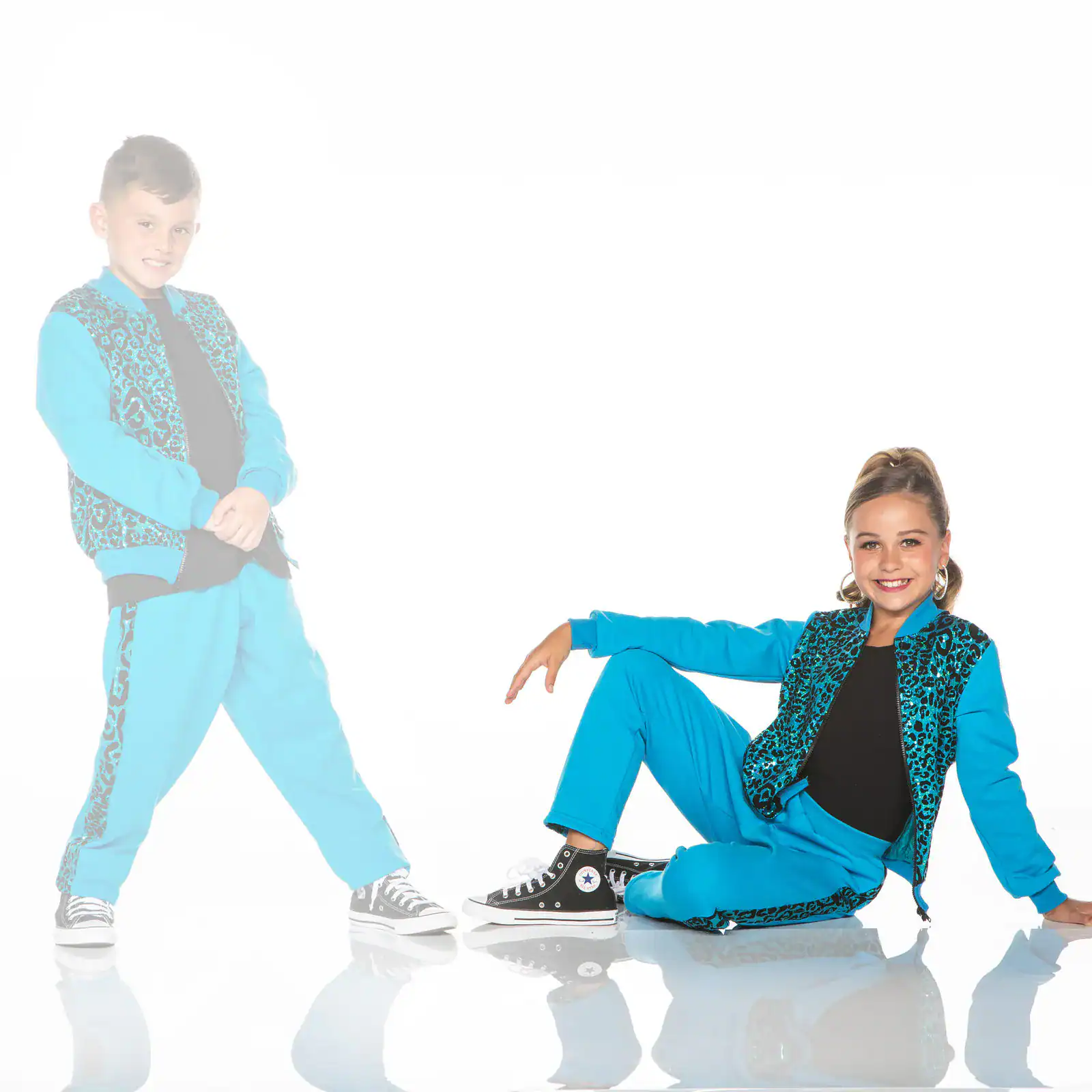 Two children in matching turquoise leopard-print dance outfits