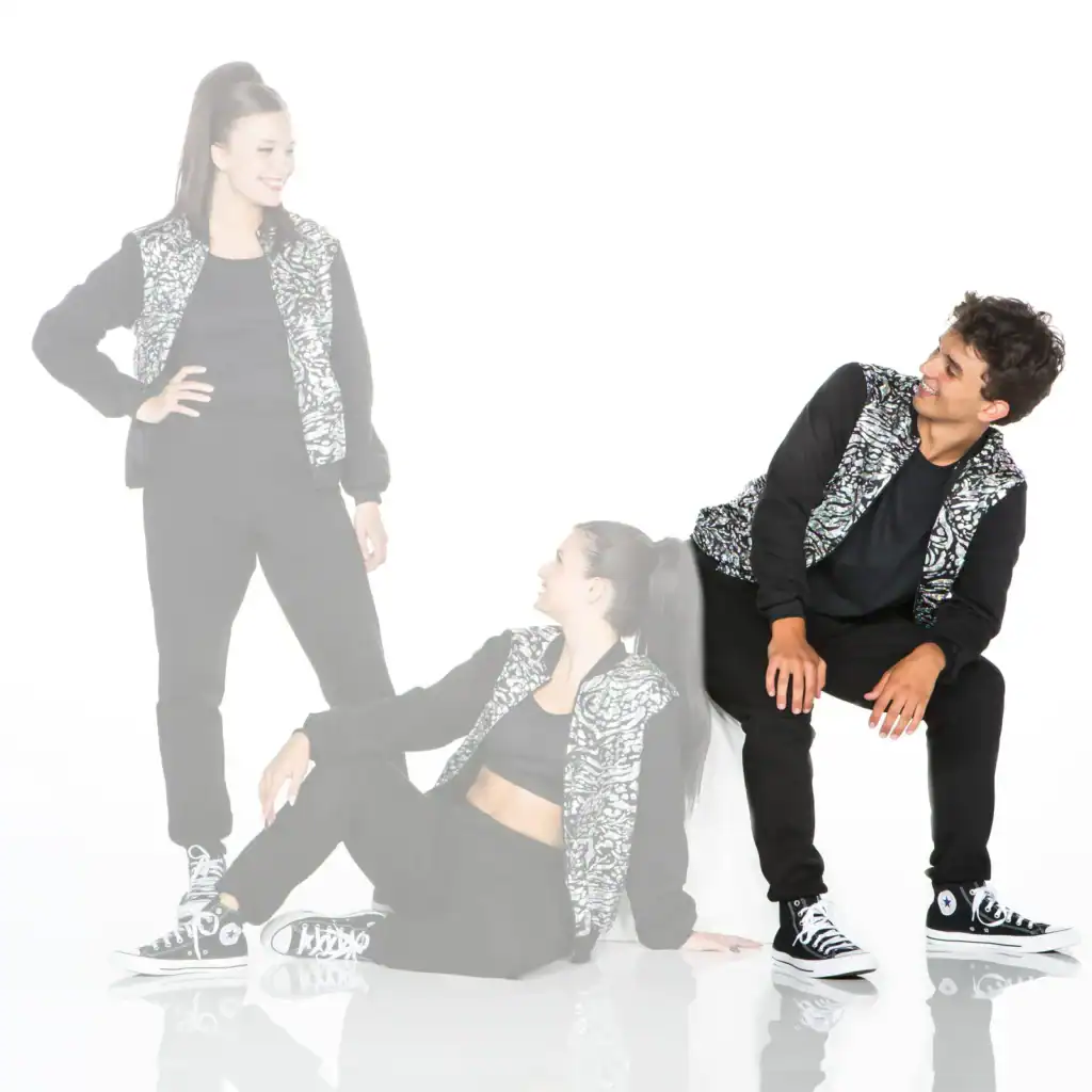 Three dancers in matching black outfits and patterned vests