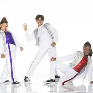 Three children posing in sparkling white dance outfits