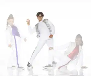 Three children posing in sparkling white dance outfits