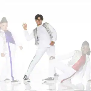 Three children posing in sparkling white dance outfits
