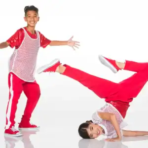 Two young dancers in red outfits pose on white background.