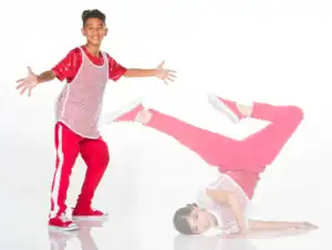 Two dancers in red outfits pose against white background.