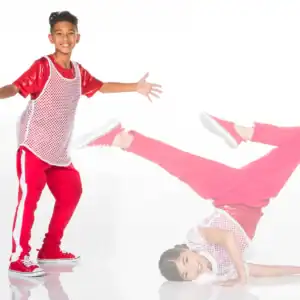 Two dancers in red outfits pose against white background.