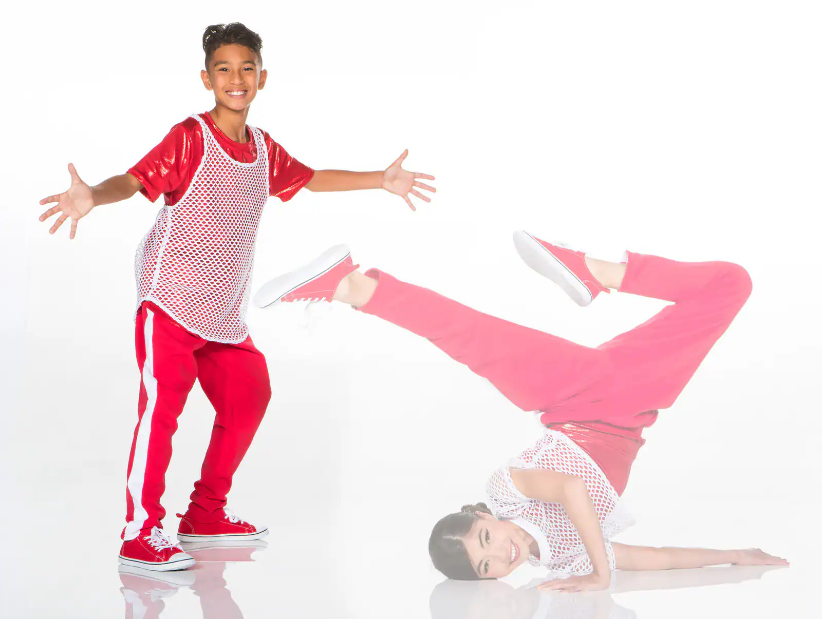 Two dancers in red outfits pose against white background.