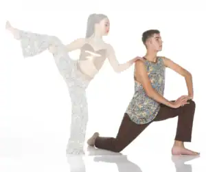 Two dancers pose in colorful patterned outfits on white background.