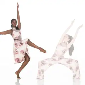 Two dancers pose in matching floral costumes against white background.