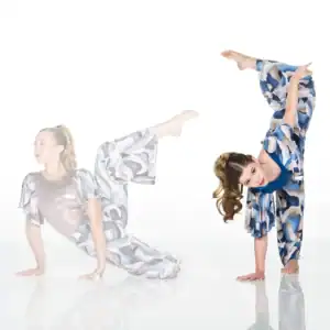 Two women in patterned dresses perform acrobatic poses.