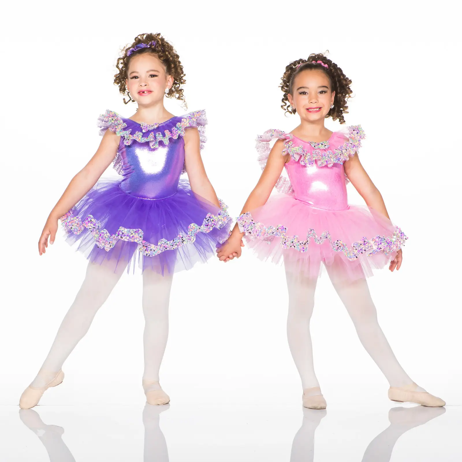 Two young ballerinas in colorful purple and pink tutus