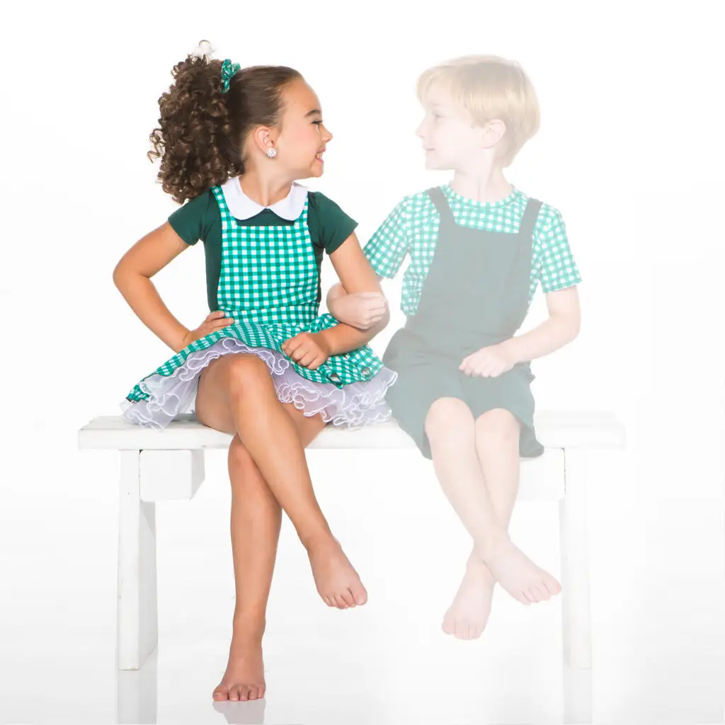 Girl in green dress sitting beside faded boy
