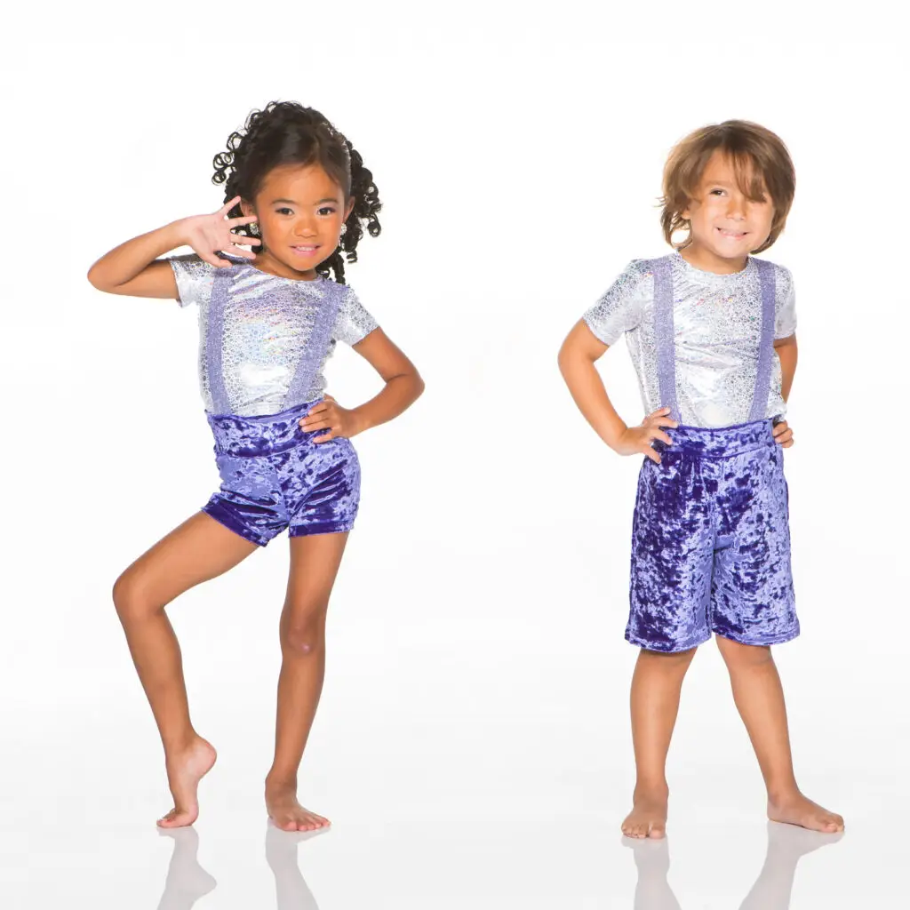 Two children model silver shirts and purple velvet shorts.