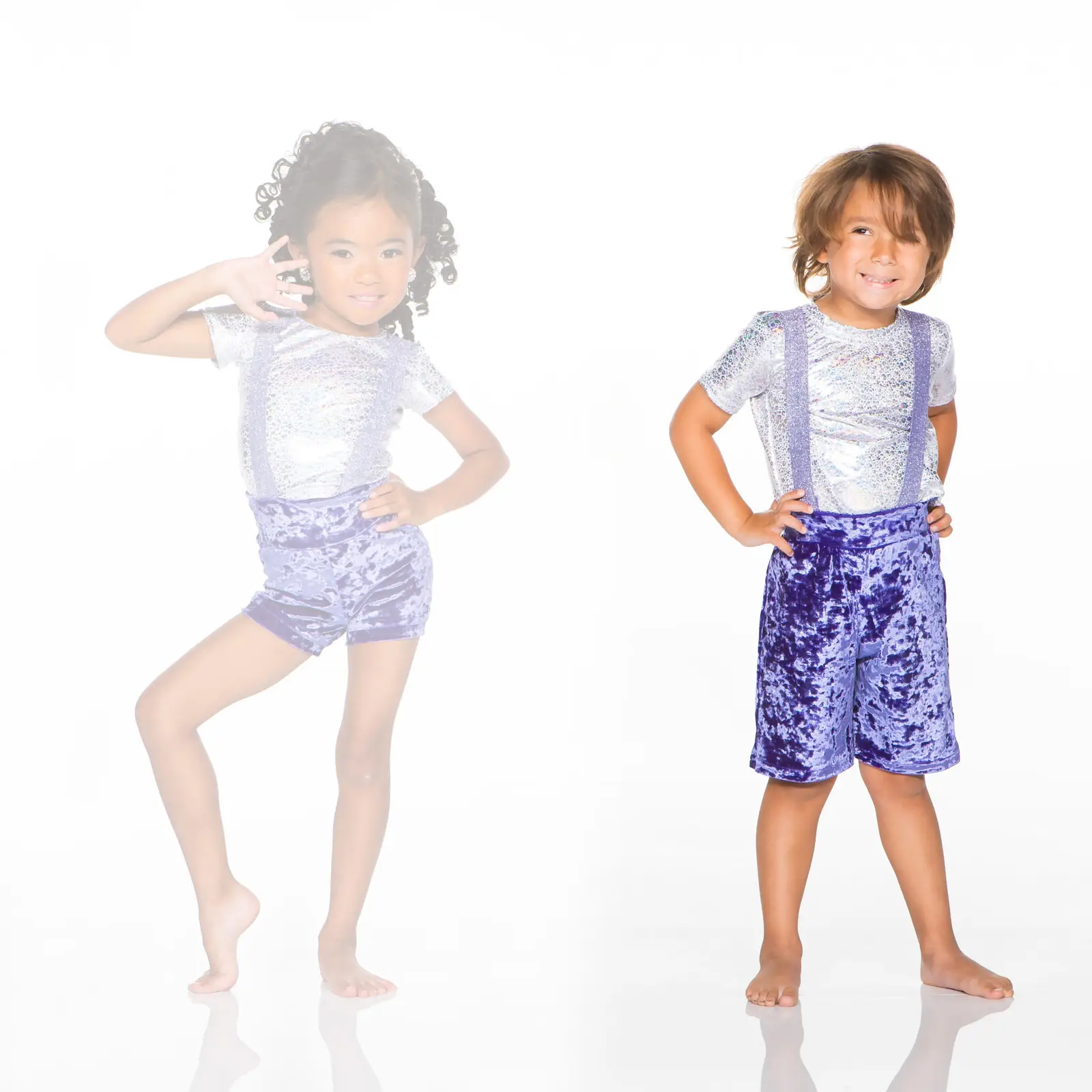 Two children modeling shiny purple outfits on a white background.
