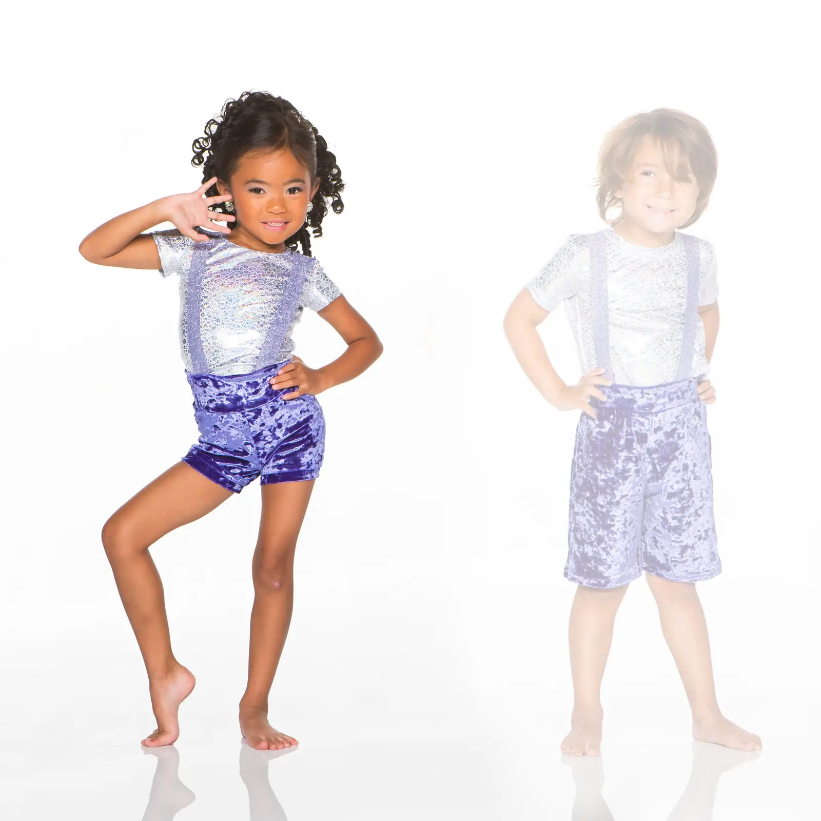 Two children modeling shiny purple outfits against white background